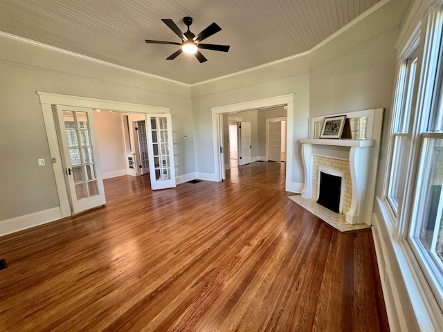 unfurnished living room with ornamental molding, hardwood / wood-style floors, a fireplace, and french doors