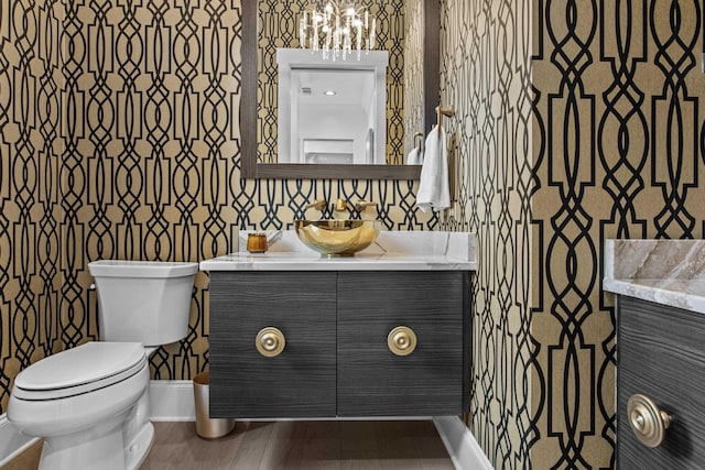 1031 Fish Trap Shls, Greensboro, GA 30642 - bathroom with vanity, toilet, baseboards, wallpapered walls, and a chandelier