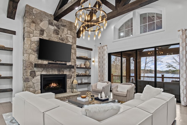 1031 Fish Trap Shls, Greensboro, GA 30642 - living area featuring built in shelves, wood finished floors, beam ceiling, a stone fireplace, and a high ceiling