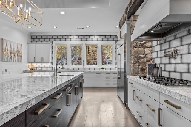 1031 Fish Trap Shls, Greensboro, GA 30642 - kitchen with a sink, premium range hood, backsplash, white cabinetry, and recessed lighting