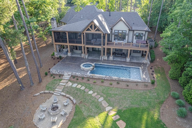 1031 Fish Trap Shls, Greensboro, GA 30642 - back of house with a sunroom, an outdoor fire pit, a patio, roof with shingles, and a pool with connected hot tub