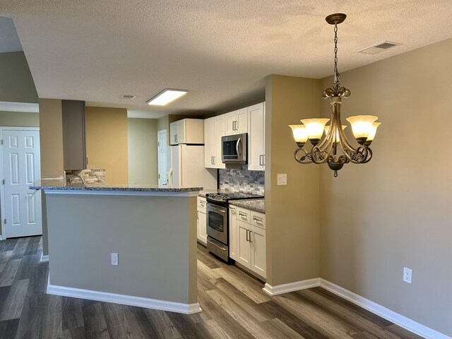 kitchen with white cabinetry, stone countertops, decorative light fixtures, dark hardwood / wood-style floors, and stainless steel appliances