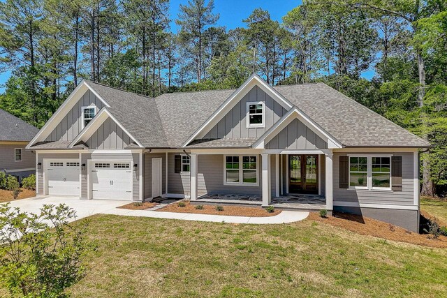 view of front of house with a porch, a garage, and a front lawn