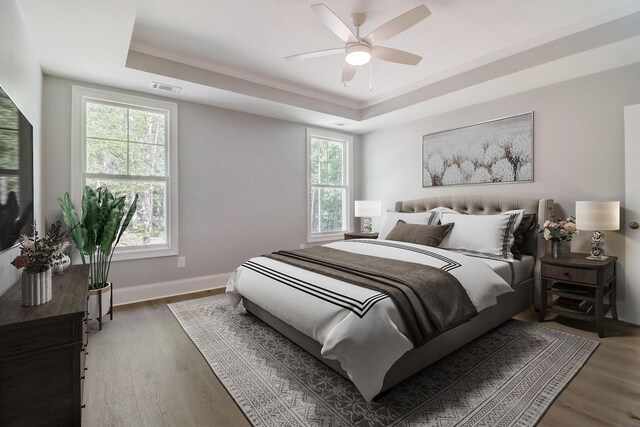 bedroom with ceiling fan, dark hardwood / wood-style floors, and a raised ceiling