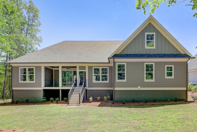 view of front of home with a front yard, ceiling fan, and covered porch