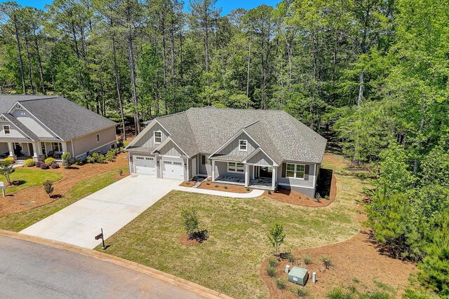 craftsman house featuring a garage, a front yard, and covered porch