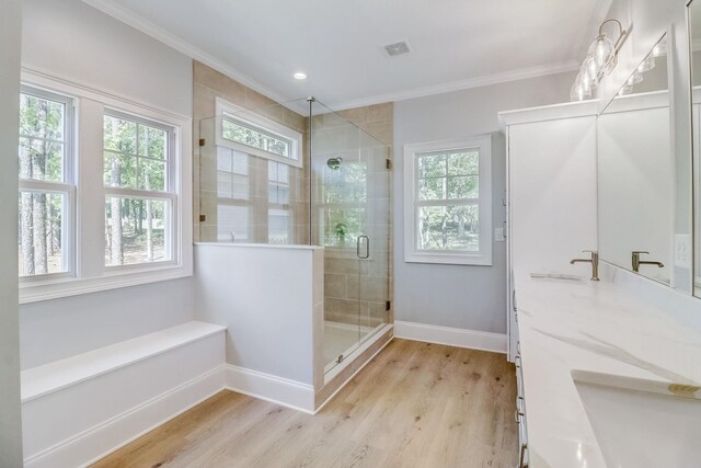 bathroom featuring vanity, a shower with shower door, ornamental molding, and wood-type flooring