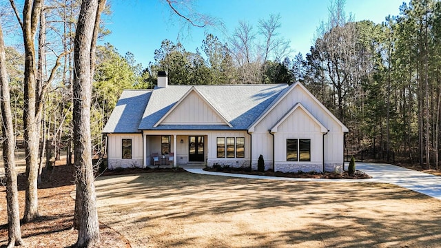 modern farmhouse style home featuring a front yard