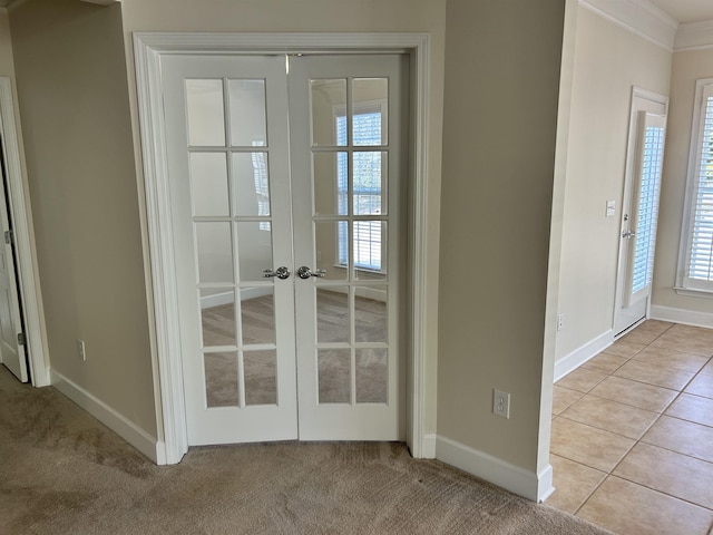 entryway featuring french doors, plenty of natural light, crown molding, and light tile patterned floors