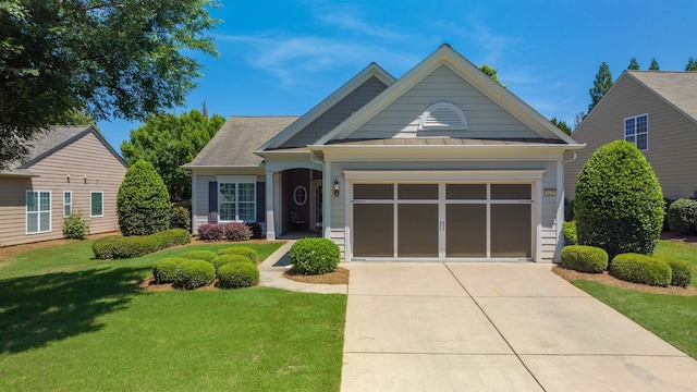 craftsman inspired home featuring a garage and a front lawn