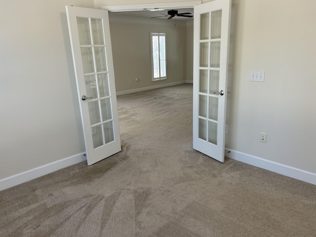 spare room with french doors, light colored carpet, ornamental molding, and ceiling fan