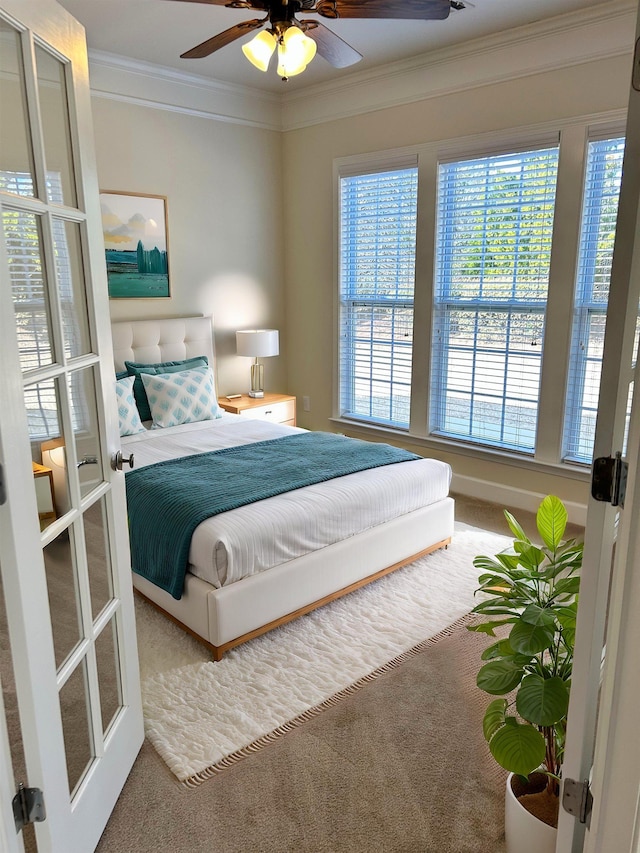 bedroom with ceiling fan, ornamental molding, and carpet floors