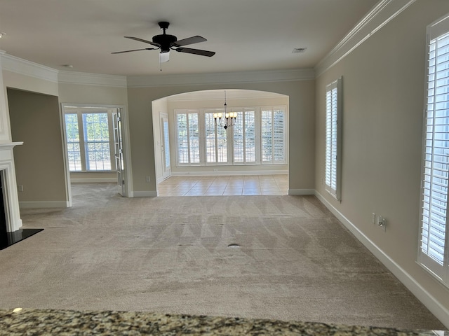 unfurnished living room with ornamental molding, ceiling fan with notable chandelier, and light carpet