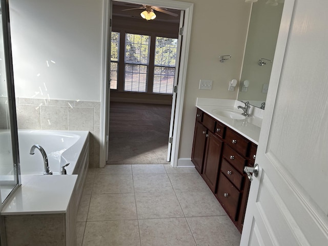 bathroom featuring ceiling fan, vanity, a bathing tub, and tile patterned flooring