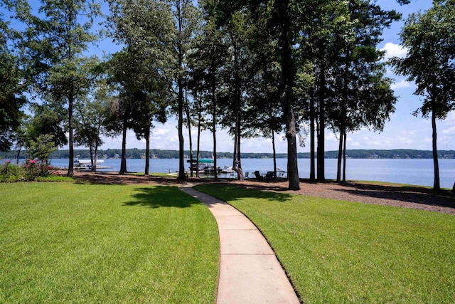 view of property's community featuring a lawn and a water view