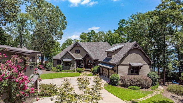 craftsman-style home featuring a garage, stone siding, concrete driveway, and a front yard