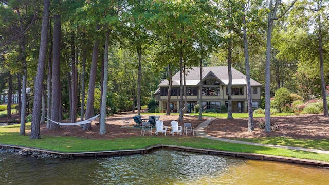 rear view of house with a lawn and a water view