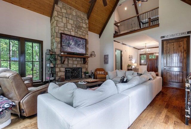 146 Long Island Dr, Eatonton, GA 31024 - living room featuring high vaulted ceiling, a wood ceiling with exposed beams, plenty of natural light, a chandelier, and a stone fireplace