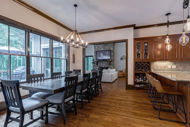 146 Long Island Dr, Eatonton, GA 31024 - dining space with crown molding, dark wood finished floors, plenty of natural light, a chandelier, and a fireplace