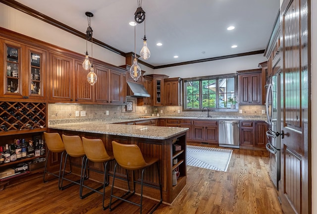 146 Long Island Dr, Eatonton, GA 31024 - kitchen featuring stainless steel appliances, ornamental molding, light stone counters, wood finished floors, and under cabinet range hood