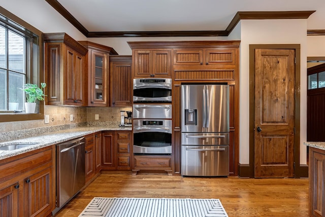 146 Long Island Dr, Eatonton, GA 31024 - kitchen with stainless steel appliances, crown molding, a warming drawer, plenty of natural light, and decorative backsplash