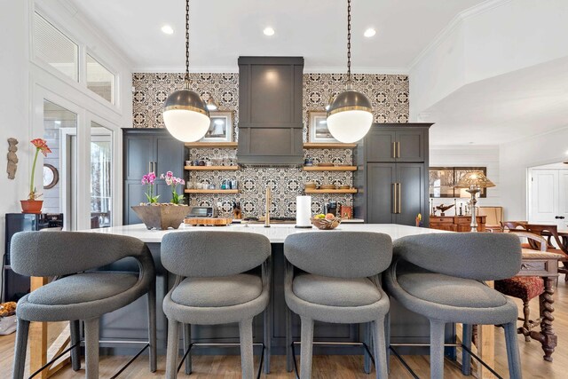 kitchen with pendant lighting, crown molding, dark wood-type flooring, tasteful backsplash, and custom exhaust hood