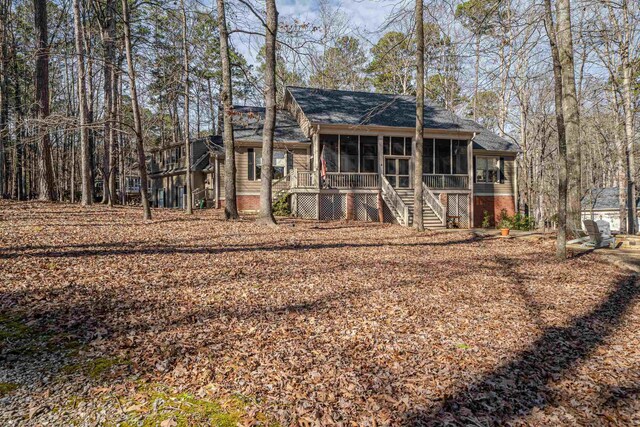 rear view of house featuring a sunroom