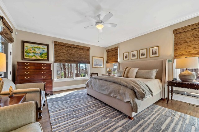 bedroom featuring ceiling fan, ornamental molding, and dark hardwood / wood-style floors