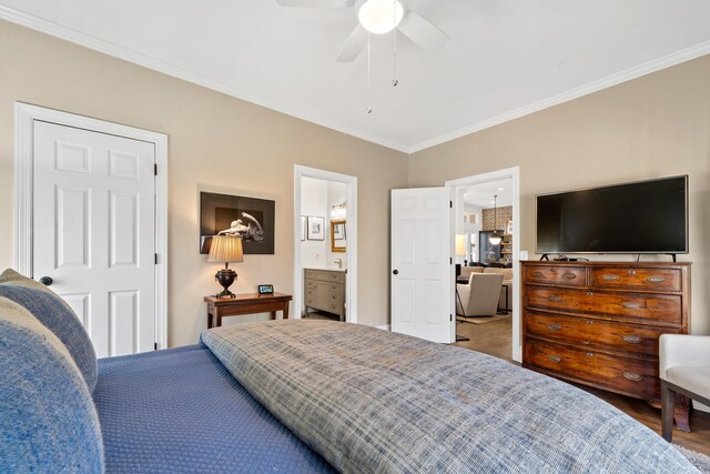 bedroom featuring crown molding, ensuite bath, and ceiling fan