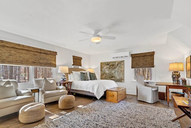 bedroom with ceiling fan, hardwood / wood-style floors, and an AC wall unit