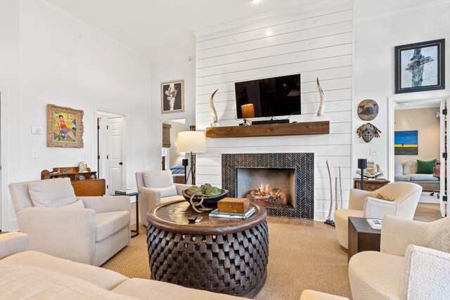 living room featuring a fireplace, ornamental molding, and a high ceiling