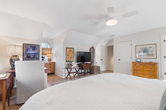 bedroom featuring ceiling fan, lofted ceiling, and light wood-type flooring