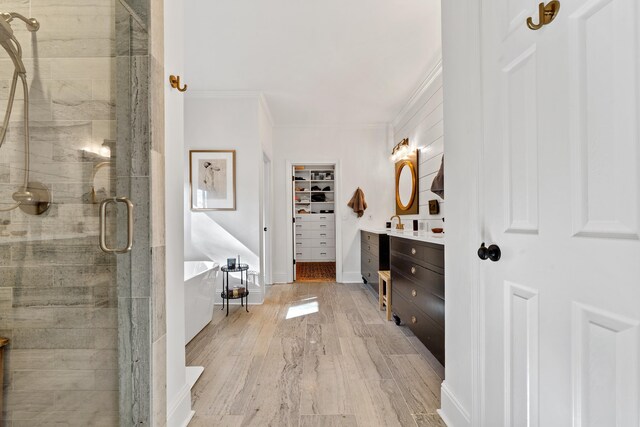 bathroom with crown molding, vanity, separate shower and tub, and hardwood / wood-style flooring