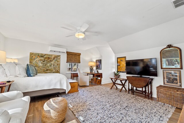 bedroom featuring hardwood / wood-style flooring, vaulted ceiling, a wall unit AC, and ceiling fan