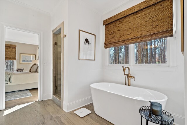 bathroom with crown molding, wood-type flooring, and separate shower and tub