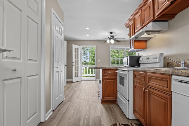 163 Knight Dr, Milledgeville, GA 31061 - kitchen featuring white appliances, under cabinet range hood, wood finished floors, brown cabinets, and recessed lighting