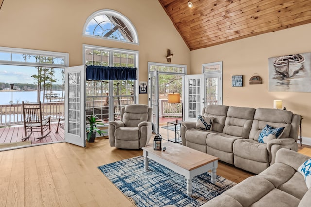 living room with wood ceiling, light wood-type flooring, high vaulted ceiling, and a water view