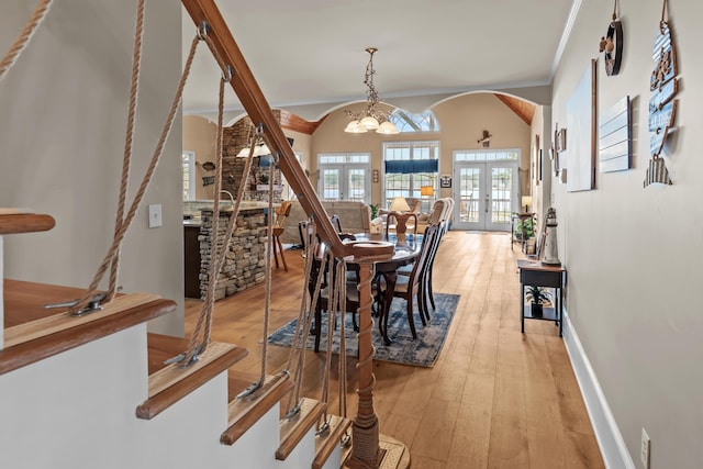 dining area with ornamental molding, an inviting chandelier, light hardwood / wood-style floors, and french doors