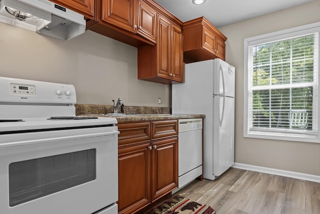 163 Knight Dr, Milledgeville, GA 31061 - kitchen with white appliances, under cabinet range hood, light wood-style floors, baseboards, and brown cabinets