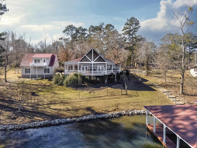 back of house featuring a water view and a yard