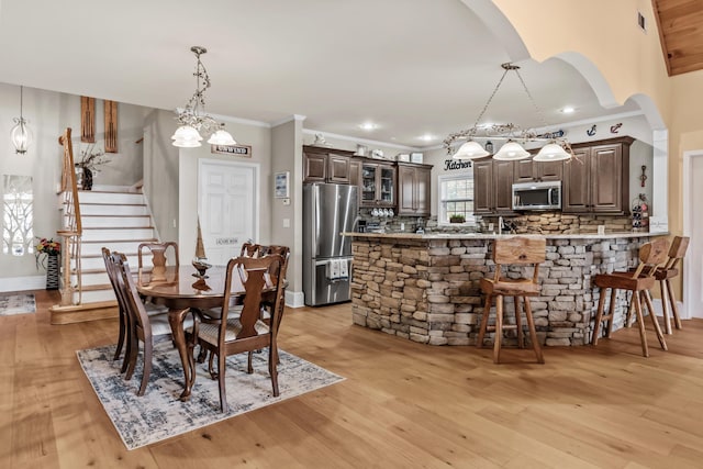 dining space featuring ornamental molding and light hardwood / wood-style floors