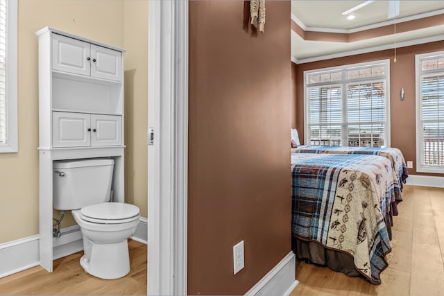 bedroom featuring ornamental molding and light hardwood / wood-style flooring