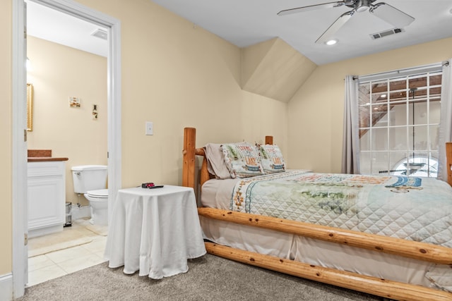 bedroom with light carpet, connected bathroom, and ceiling fan