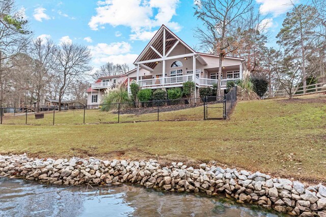 rear view of property with a lawn and a water view