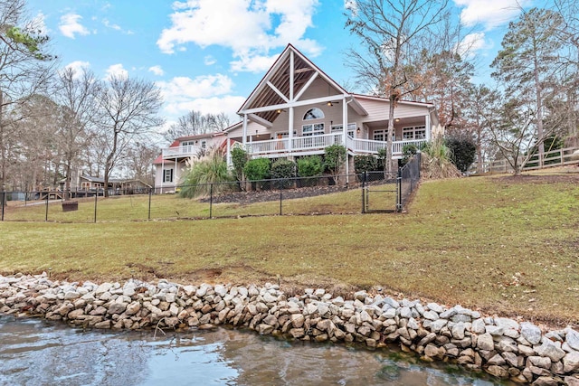 rear view of property with a lawn and a water view