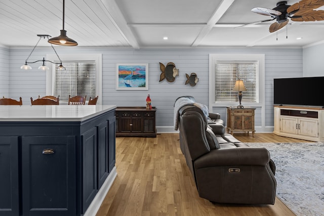 living room with beam ceiling, light hardwood / wood-style floors, and ceiling fan