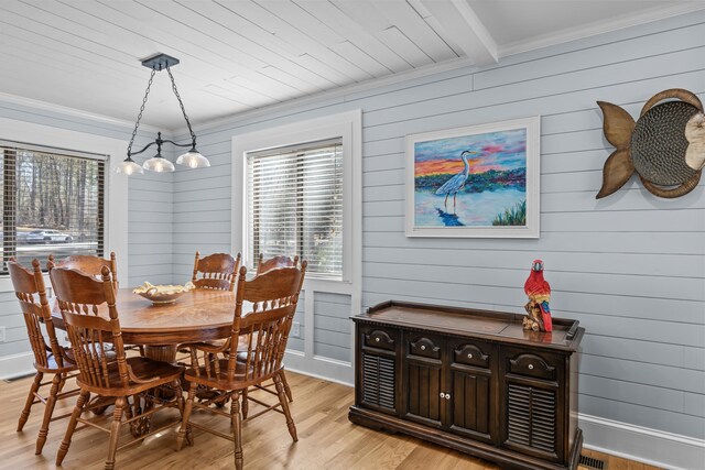 dining room featuring ornamental molding, beam ceiling, and light hardwood / wood-style floors