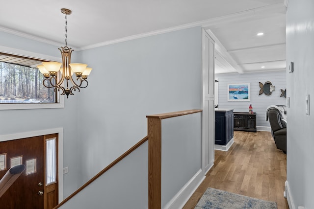 entrance foyer featuring crown molding, an inviting chandelier, and hardwood / wood-style floors