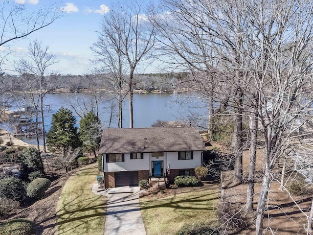 bi-level home featuring a garage, a front yard, and a water view