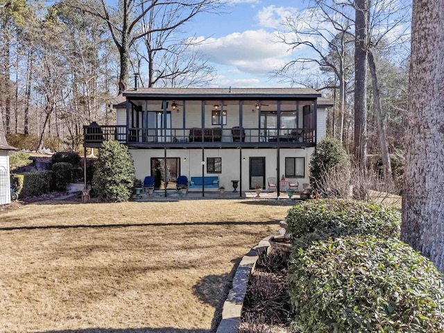 rear view of property with a yard, a patio area, and a balcony